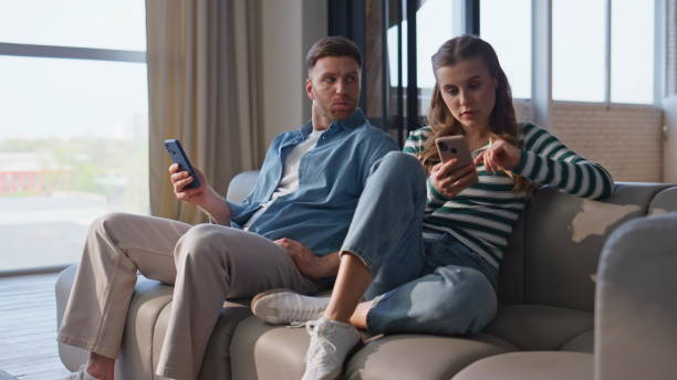 istock Offended couple browsing smartphones at domestic weekend. Internet addicted pair 2191868062