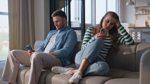 istock Boring couple focused mobile phones sitting couch. Spouses ignoring each other 2191868150