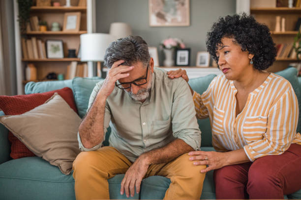 istock A mixed-race woman comforts her husband who has a bad headache while sitting on the sofa in the living room 2191870248