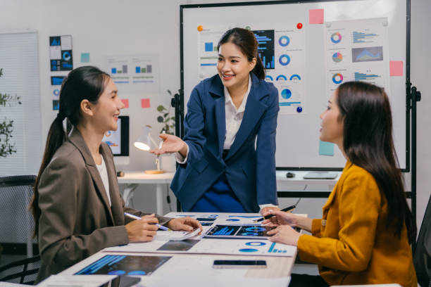istock Three asian businesswomen are discussing charts and data analysis during a productive meeting in a modern office, fostering collaboration and strategic decision-making 2191871608