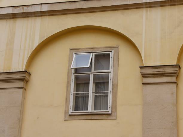 istock Yellow Stucco Wall with Classic European Architecture Featuring an Open Window with Minimalist Design 2191872200