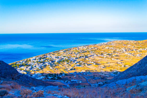 Aerial view from Mesa Vouno rugged mountain at sunrise of Perissa-coastal village on the Greek island of Santorini. It’s known for the Perissa Black Sand Beach, backed by restaurants and bars.Sep 2013