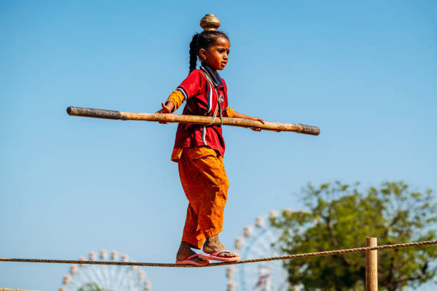 Pushkar, Rajasthan, India - November 11, 2024: A young child demonstrating amazing balancing skills on a tightrope during Pushkar Fair.
