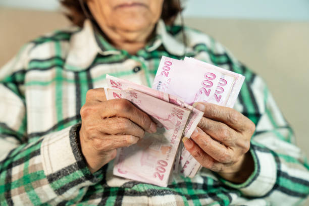 istock Hands holding and counting Turkish money 2191883584