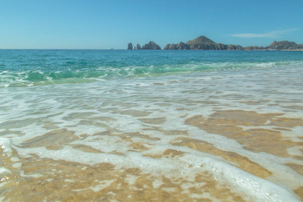 Sandy beach with the blue ocean and blue sky background