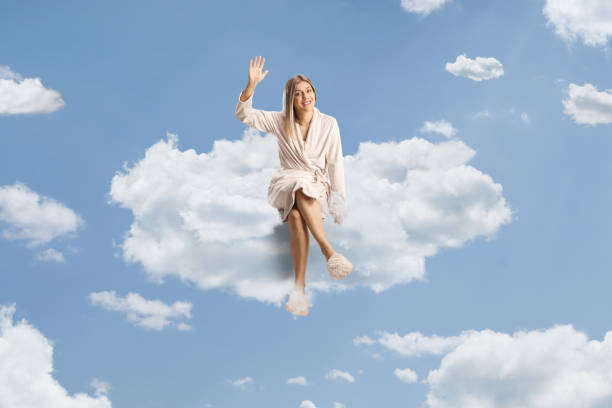 istock Beautiful young woman in a bathrobe sitting on a cloud 2191886517