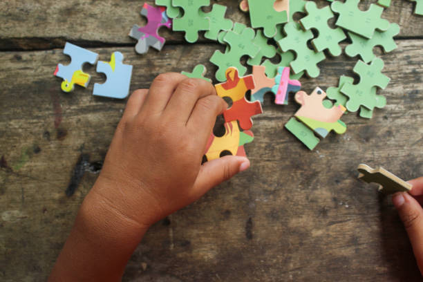 istock little child's hands playing educational game jigsaw puzzle 2191890546