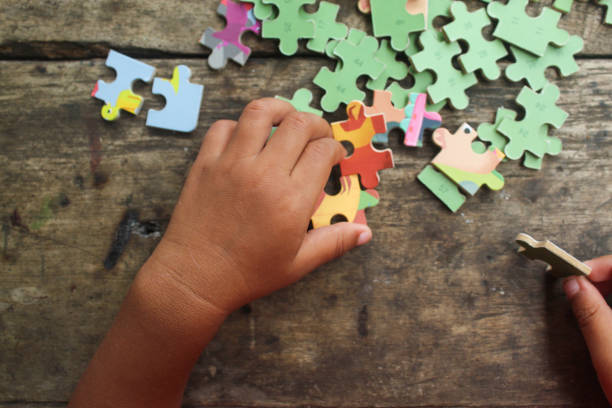 istock little child's hands playing educational game jigsaw puzzle 2191890547