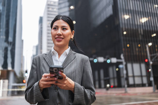 istock Businesswoman checking phone while commuting in urban Houston 2191890778