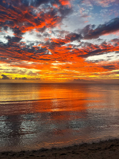 istock The tropical island sunset features intense colors across the sky, with dark clouds creating a dramatic contrast over the peaceful ocean 2191896289