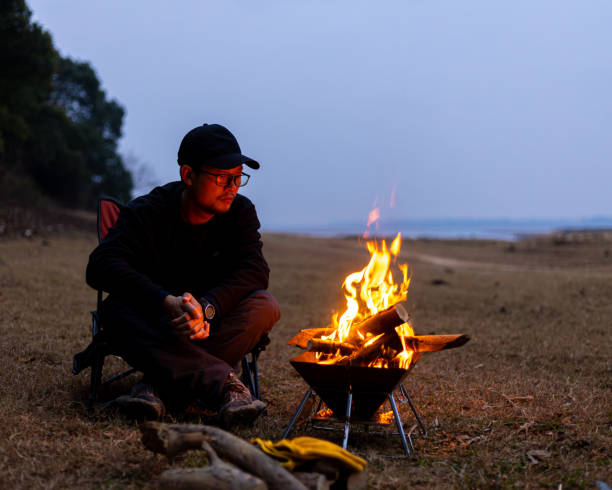 A Chinese man and a camping bonfire outdoors