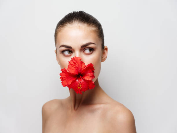 istock woman with bare shoulders red flower decoration cropped view 2191911252