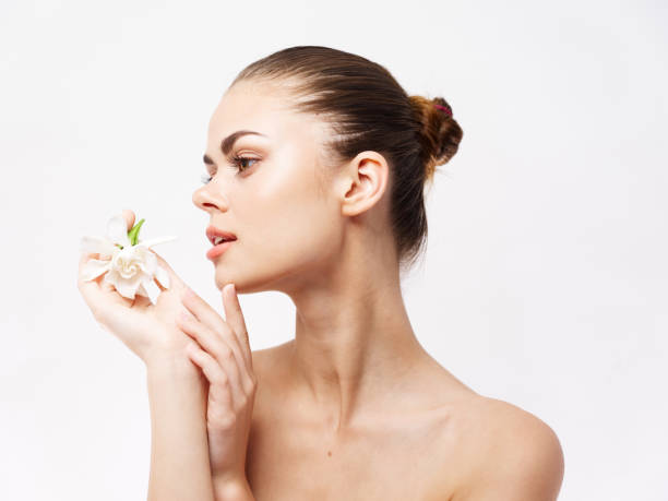 istock woman with bare shoulders white flower cosmetics light background 2191911319