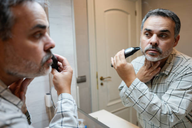 istock Mature man trimming his beard in the bathroom mirror 2191920985