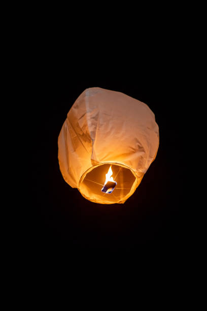 istock Sky lantern drifting softly through dark night, radiating warm glow, symbolizing dreams ascending toward infinite starry darkness 2191921581