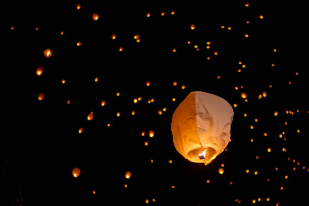 istock Sky lanterns drifting softly in nighttime darkness, large lantern prominent, symbolizing shared hopes, dreams, ethereal moment of collective aspiration 2191921596