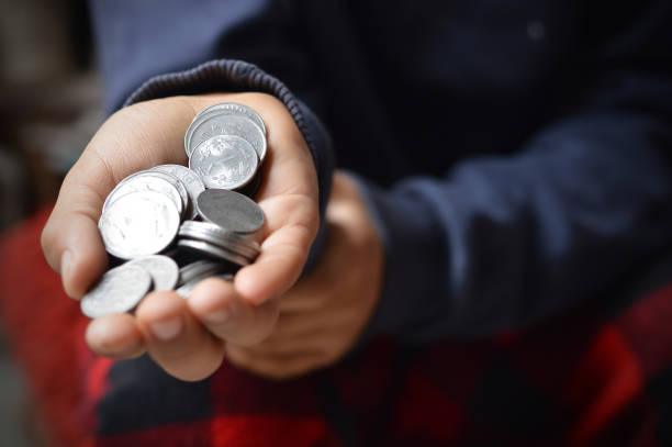 istock Horizontal click of scattered Indian currency coins spread or scattered randomly over open spread hands like alms in beggar's hands with  Depth of field - Focus on coins placed at the end 2191921953