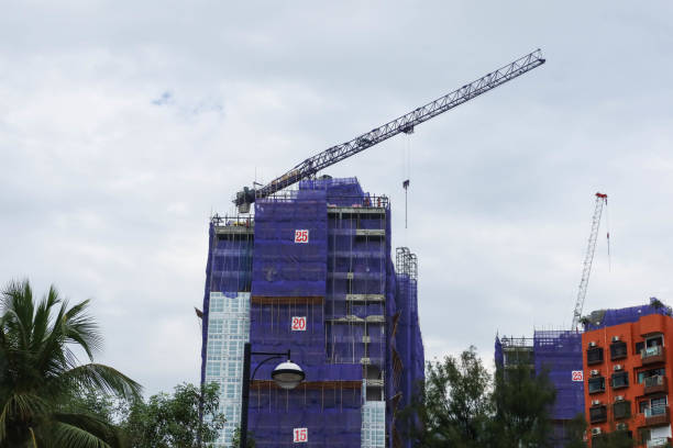 Gold Coast Bay, Tuen Mun, Hong Kong- 3 Dec 2024: construction site in daytime with construction tower crane and purple safety net