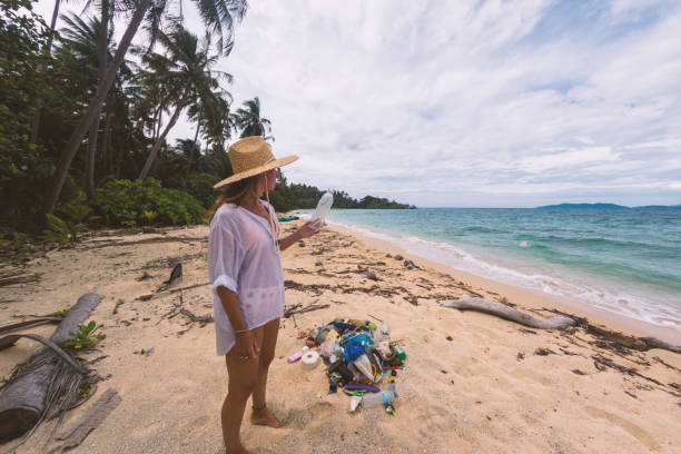 istock Woman Cleaning Litter on Remote Tropical Beach 2191932719