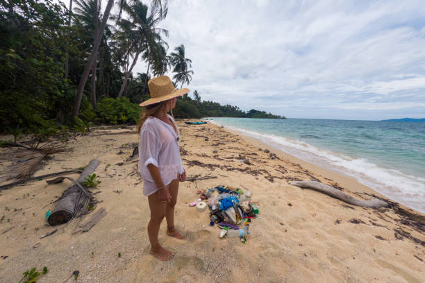 istock Woman Cleaning Litter on Remote Tropical Beach 2191932720