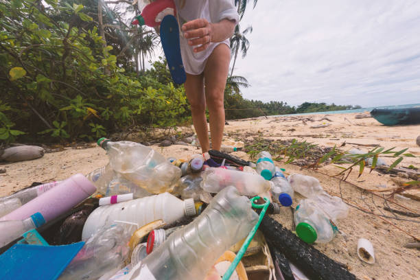 istock Woman Collecting Plastic Waste on Polluted Beach 2191932824