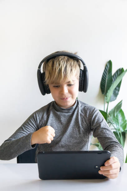 istock Happy child boy winning while playing with his digital tablet. 2191933343