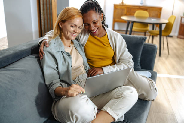 istock Mid adult lesbian couple using laptop at home 2191934097