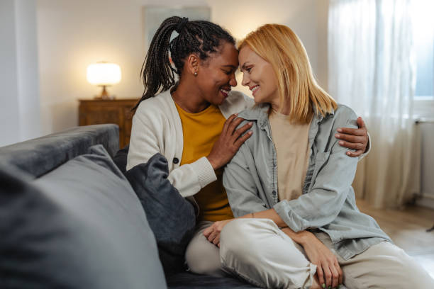 istock Two women sitting together sharing a close and joyful moment on a sofa 2191934446