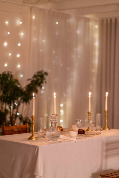 istock Romantic dinner table setting with candles and fairy lights 2191936239