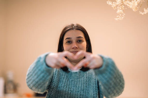 istock Young woman making heart shape with hands, showing love and affection 2191936492
