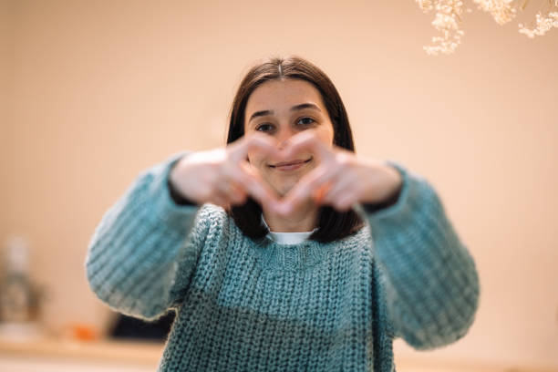 istock Young woman making heart shape with hands and smiling 2191936493