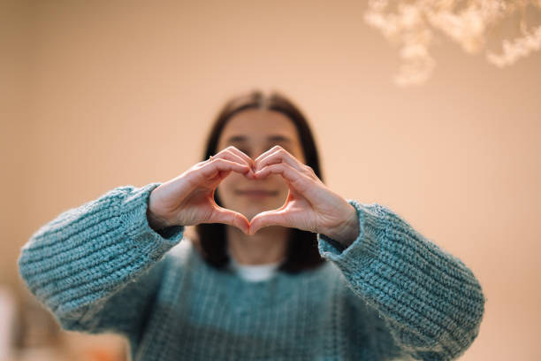 istock Young adult woman making heart shape with hands 2191936576