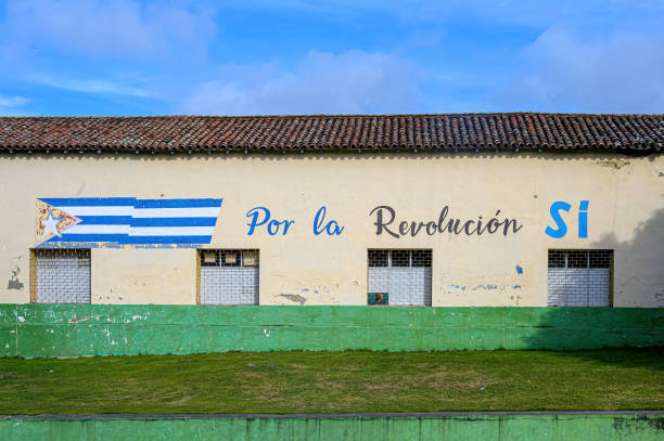 Santa Clara, Cuba - December 23, 2024: Propaganda slogan and Cuban flag in the wall of an old building. It reads For The Revolution Yes.