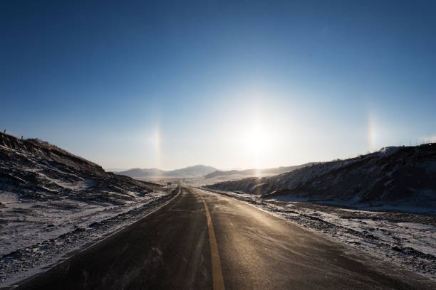 In winter, the road in the grassland has a beautiful halo