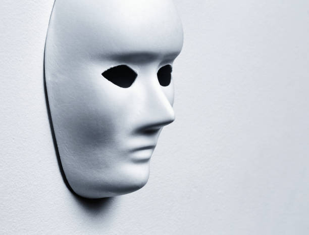 istock White paper mask with a blank expression, hanging on a white wall with copy space 2191949005