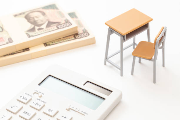 a desk, a calculator and a stack of bills on a white background. - 給付金 ストックフォトと画像