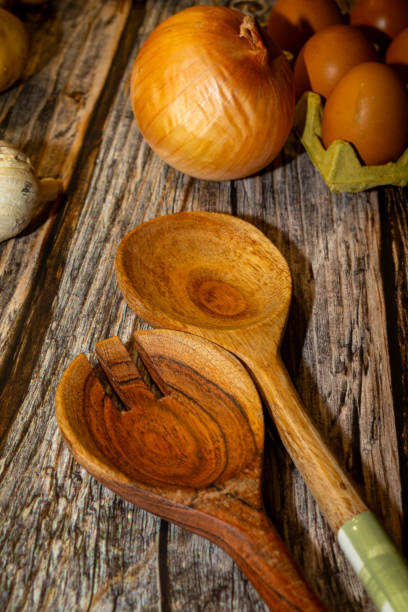 istock Raw garlic potatoes onion and kitchen spoons on wooden table 2191958724