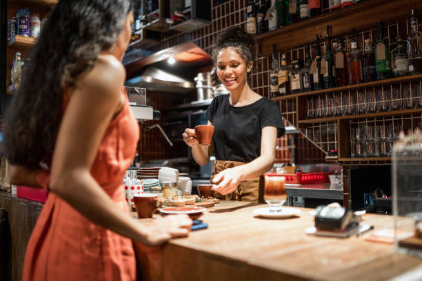 istock Professional Aboriginal Server Engages With Guest At Cozy Cafe Counter 2191960634