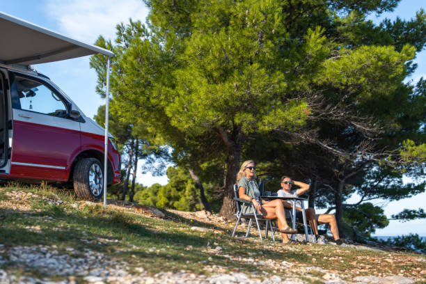 istock Relaxed Campers Sip Fresh Coffee Outside Red Van By Sea 2191960738