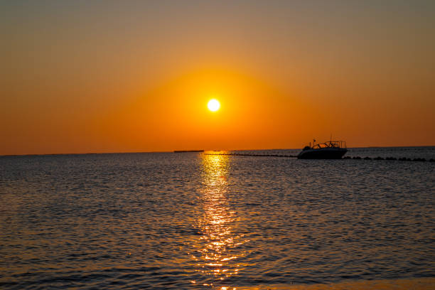 Serene Sunset Over Calm Waters with Boat