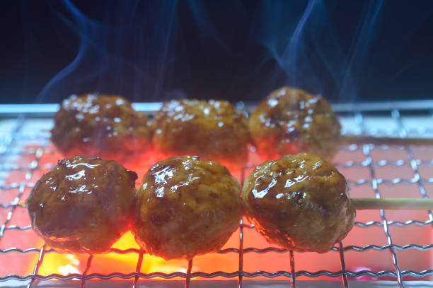 Grilling yakitori on a charcoal grill with smoke rising