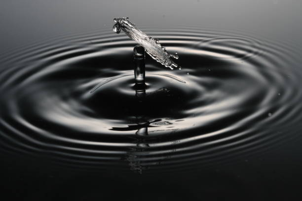 istock Droplet of liquid dropping and splashing back, making ripples. 2191975073