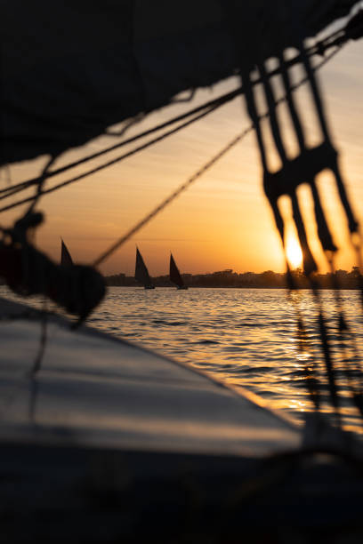Sunset on the Nile River with sail boats sailing