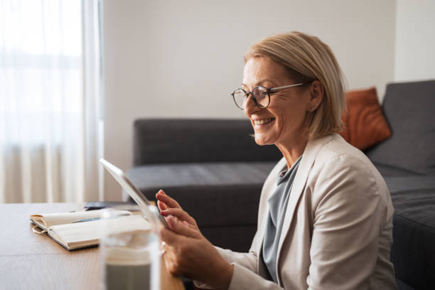 istock Smiling woman using tablet at home office desk 2191978227