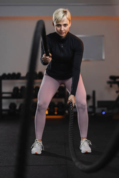istock Focused Female Athlete Performing Battle Rope Exercise 2191983392