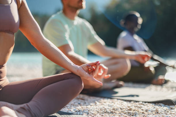 istock Group Practicing Yoga by the River at Sunrise 2191983439
