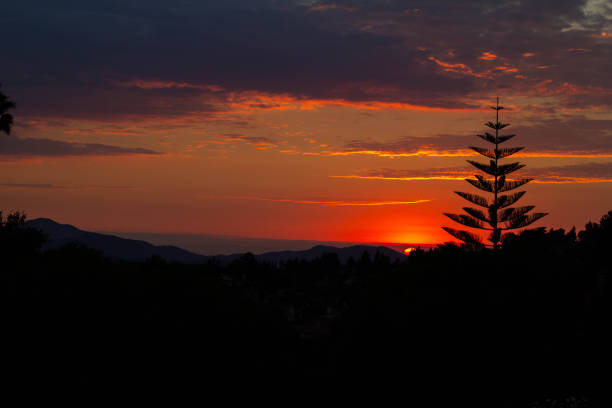 Dramatic sunset with vivid colors, silhouetted mountains and trees. in Thousand Oaks, California, United States