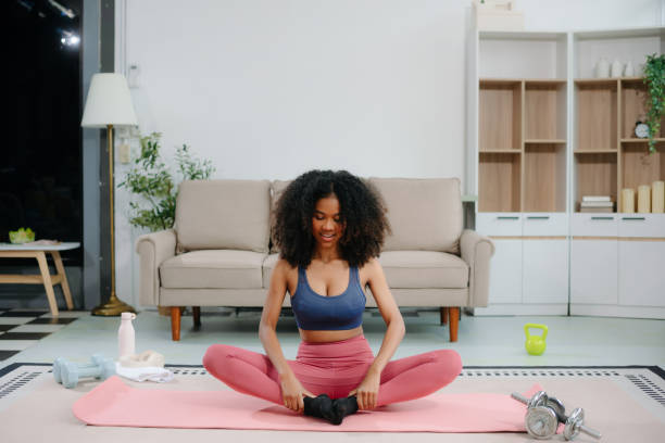 istock African Woman Doing Yoga and Watching Online Tutorials on Laptop, Training 2191991034