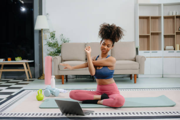 istock African Woman Doing Yoga and Watching Online Tutorials on Laptop, Training 2191991050