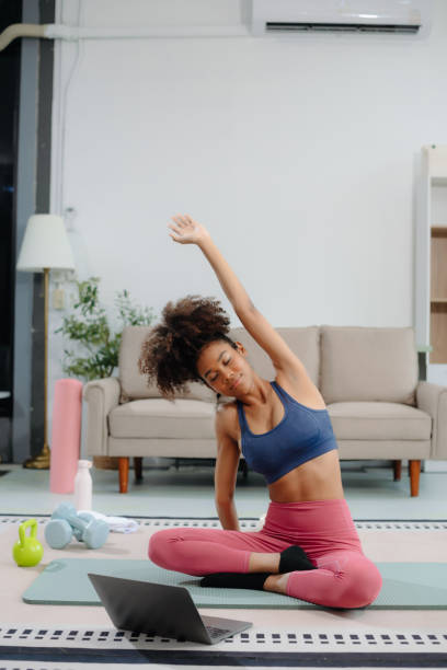 istock African Woman Doing Yoga and Watching Online Tutorials on Laptop, Training 2191991057